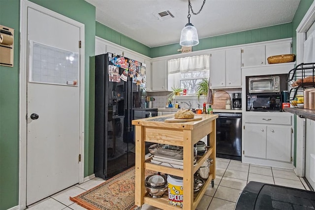 kitchen with white cabinets, light tile patterned floors, hanging light fixtures, and black appliances