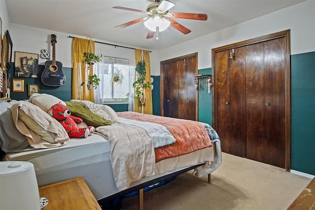 bedroom with multiple closets, ceiling fan, and wood-type flooring