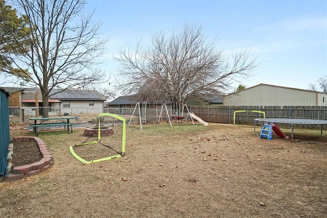 view of yard with a playground and a trampoline