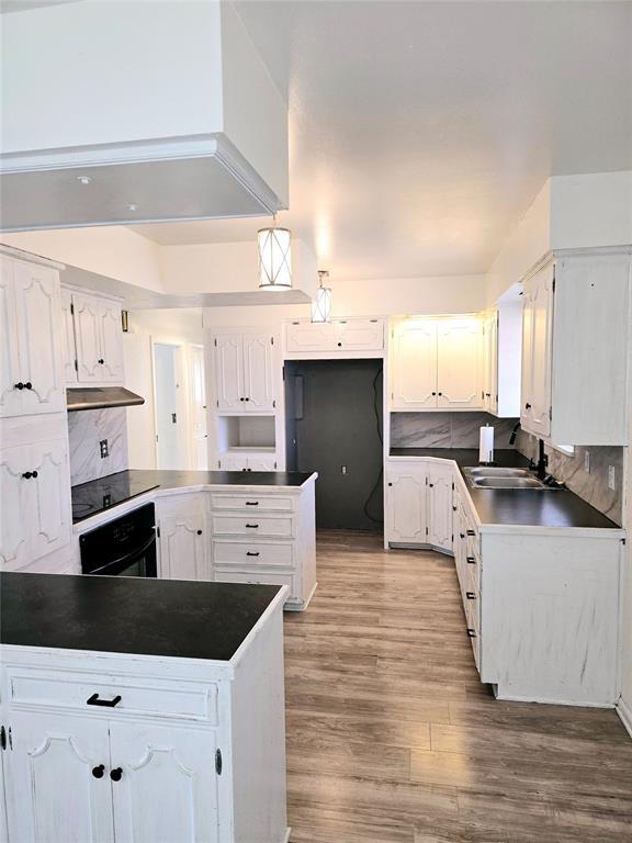 kitchen featuring white cabinetry, oven, sink, and tasteful backsplash