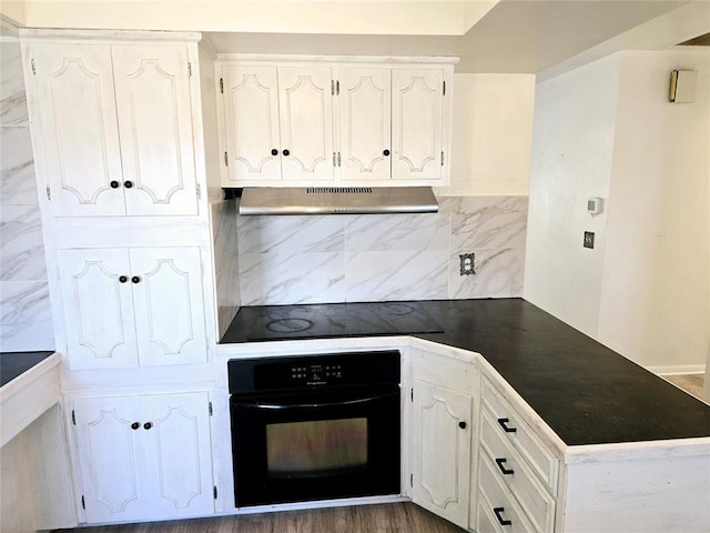 kitchen with backsplash, black appliances, and white cabinets