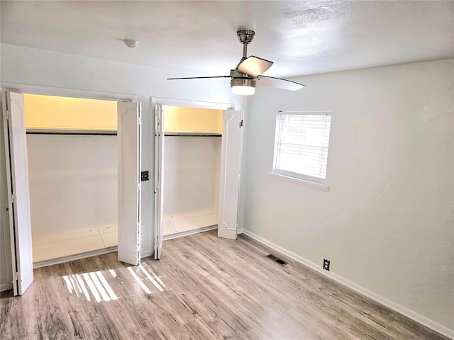 unfurnished bedroom with ceiling fan and light wood-type flooring