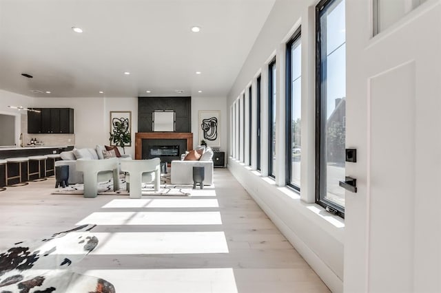 living room with a tiled fireplace and light hardwood / wood-style floors