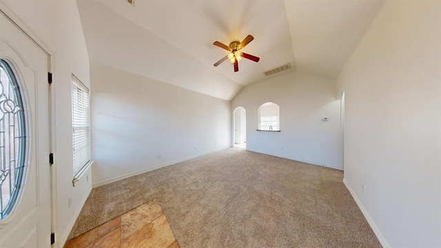 spare room featuring ceiling fan, lofted ceiling, and light carpet