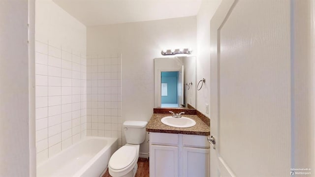 full bathroom featuring vanity, tiled shower / bath combo, and toilet