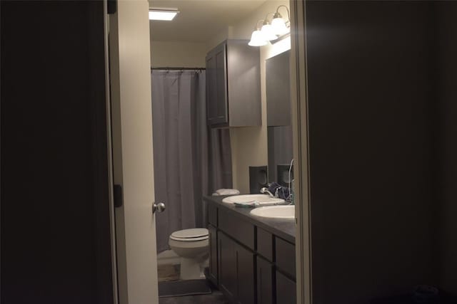 bathroom with vanity, curtained shower, and toilet