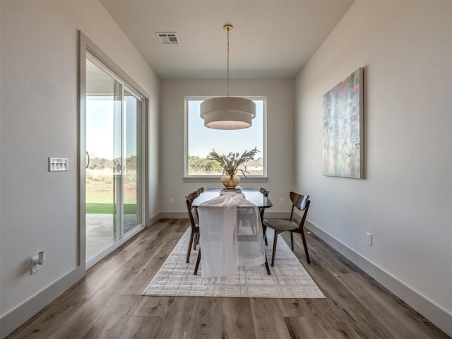 dining space with wood-type flooring