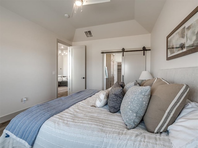 bedroom with vaulted ceiling, a barn door, and ceiling fan