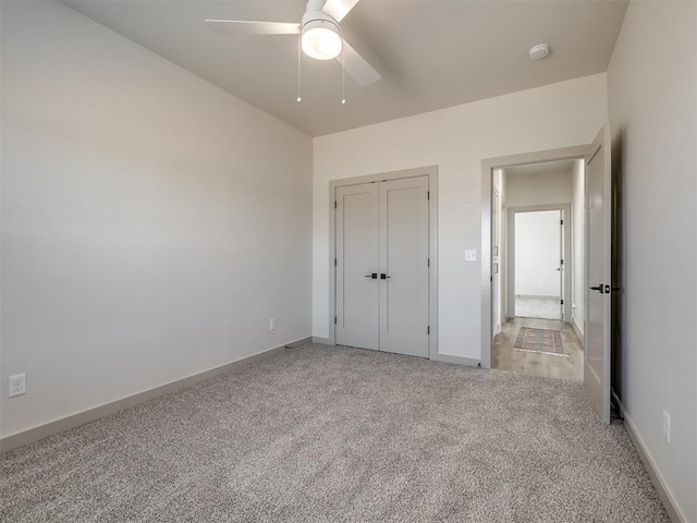 unfurnished bedroom featuring ceiling fan, light colored carpet, and a closet