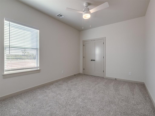 spare room featuring light colored carpet and ceiling fan