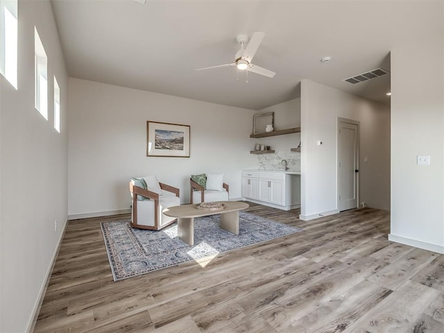 unfurnished dining area with sink, light hardwood / wood-style flooring, and ceiling fan