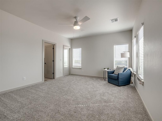 living area with carpet floors and ceiling fan