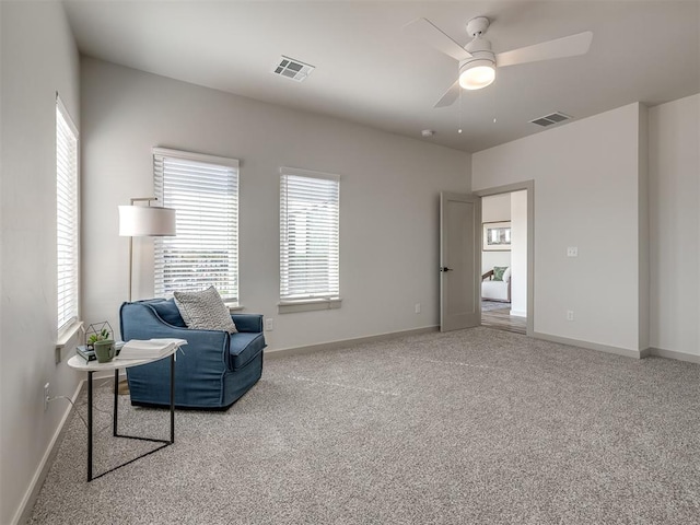 sitting room with ceiling fan and carpet flooring