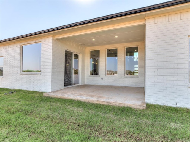 doorway to property featuring a yard and a patio