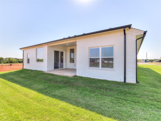 rear view of property with a lawn and a patio area