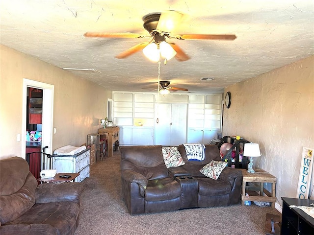 carpeted living room featuring ceiling fan and a textured ceiling