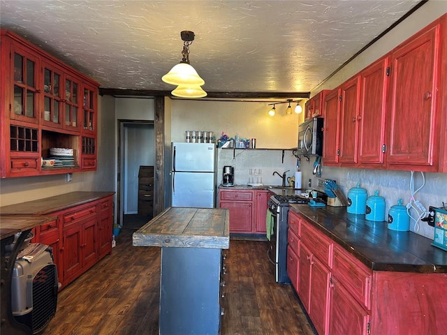 kitchen with dark wood-type flooring, appliances with stainless steel finishes, decorative light fixtures, and decorative backsplash