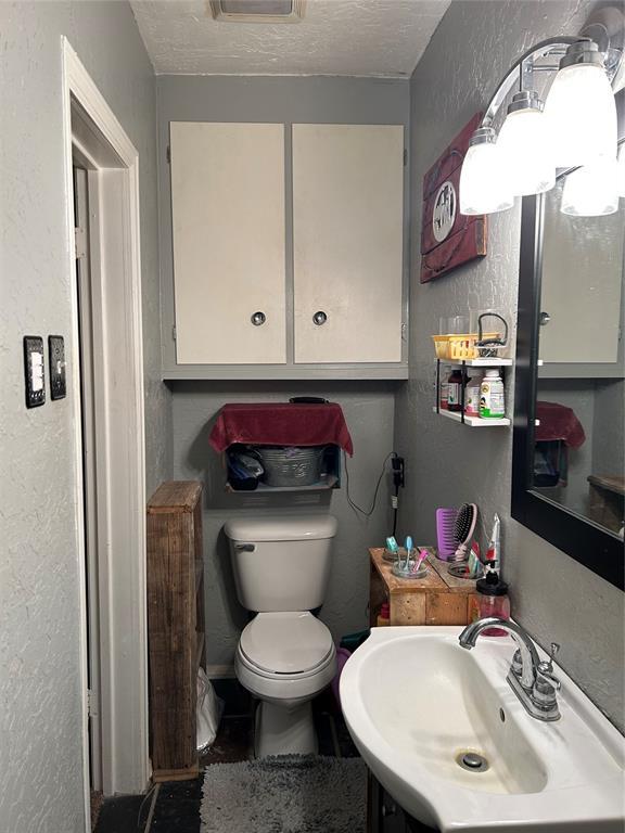 bathroom featuring vanity, toilet, and a textured ceiling