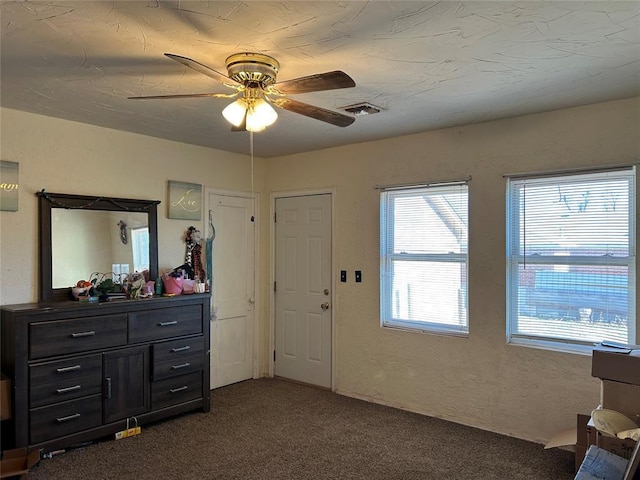 interior space featuring ceiling fan and dark colored carpet