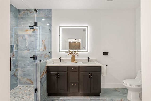 bathroom with vanity, a shower with door, and toilet