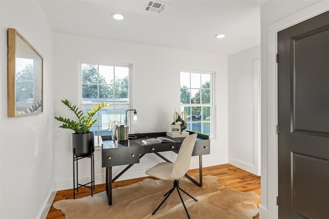 home office with light hardwood / wood-style floors