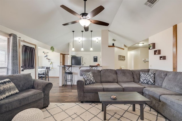 living room with ceiling fan, lofted ceiling, and light hardwood / wood-style floors