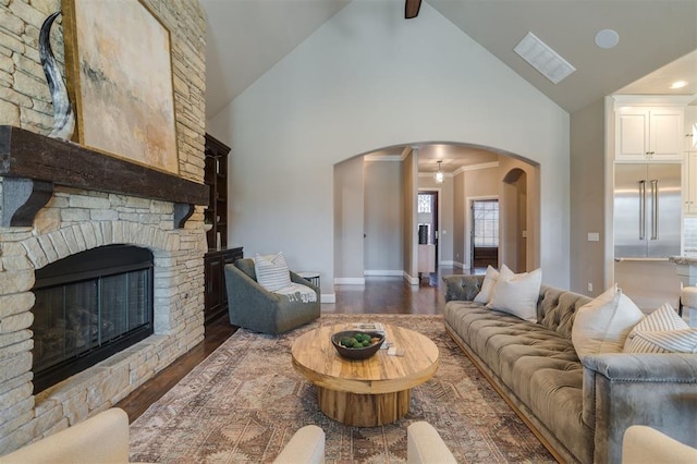 living room with dark wood-type flooring, a fireplace, and lofted ceiling with beams