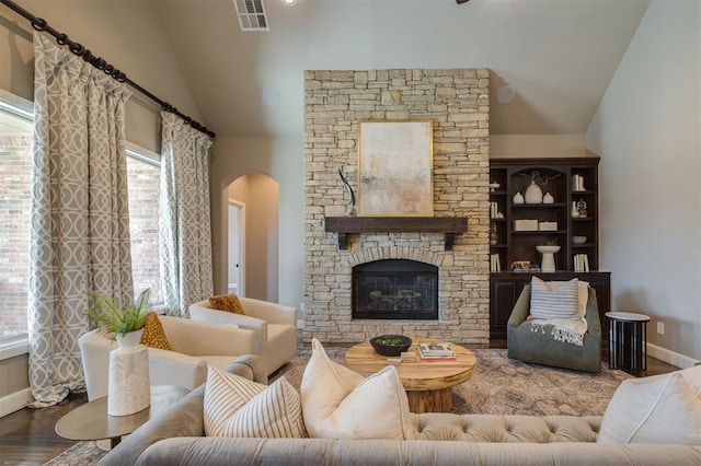 living room with high vaulted ceiling, a fireplace, and hardwood / wood-style floors