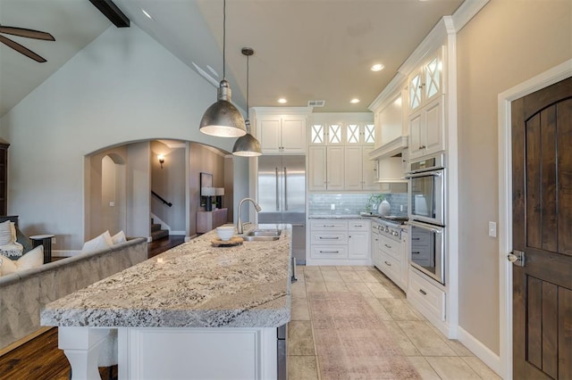 kitchen featuring white cabinetry, backsplash, and a spacious island