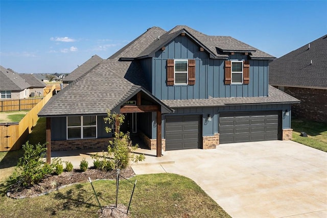 craftsman inspired home featuring a garage and a front lawn