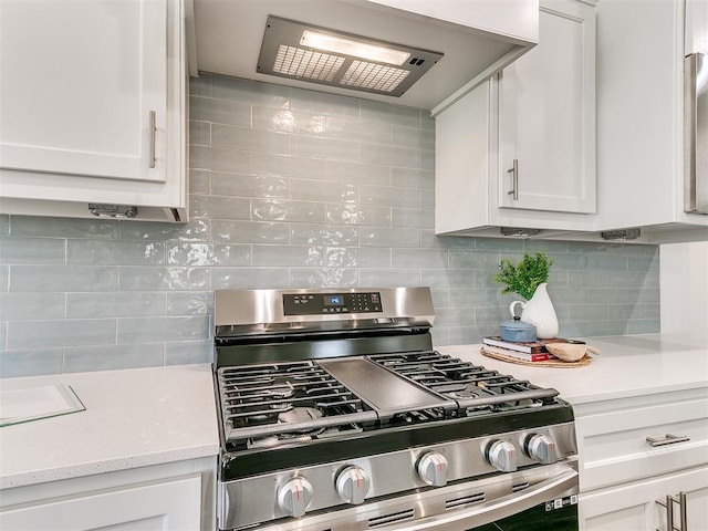 kitchen with backsplash, light stone countertops, gas stove, white cabinets, and custom exhaust hood