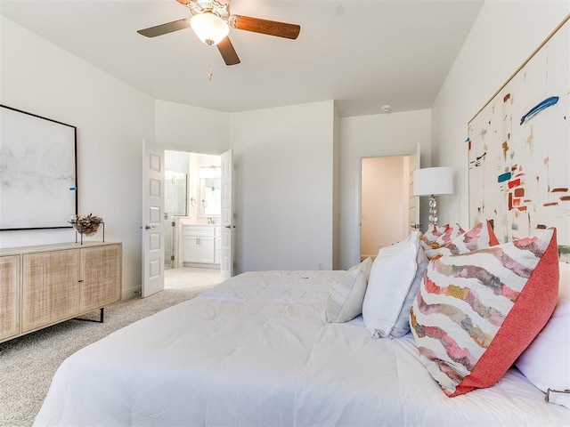 carpeted bedroom with ensuite bathroom and ceiling fan