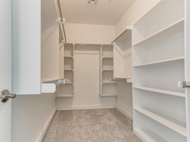 walk in closet featuring light carpet