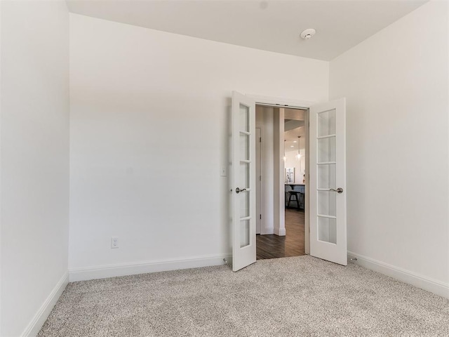 unfurnished room with carpet flooring and french doors