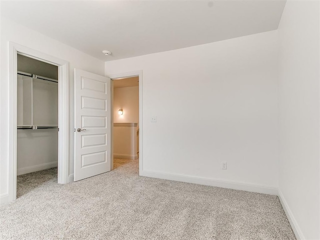 unfurnished bedroom featuring light carpet and a closet