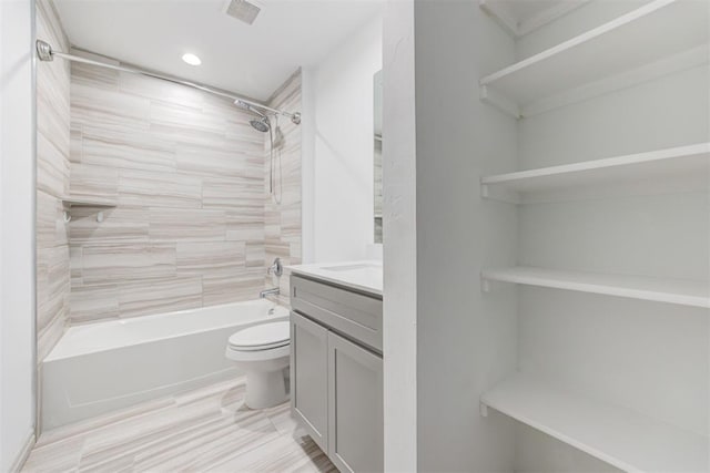 full bathroom featuring tiled shower / bath combo, vanity, and toilet