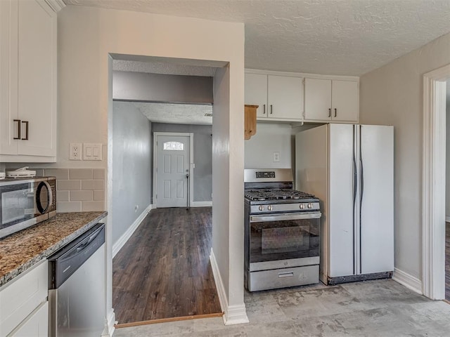 kitchen with stainless steel appliances, tasteful backsplash, white cabinets, a textured ceiling, and light stone countertops