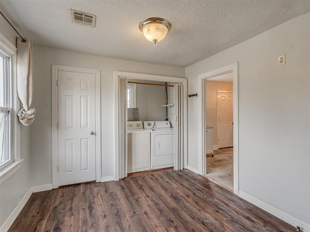 washroom featuring washer and clothes dryer, visible vents, wood finished floors, laundry area, and plenty of natural light