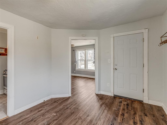 entrance foyer featuring a textured ceiling, baseboards, and wood finished floors