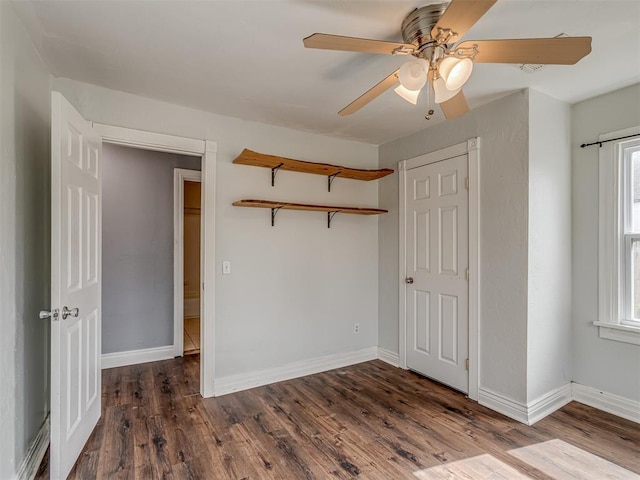 unfurnished bedroom featuring a ceiling fan, baseboards, and wood finished floors