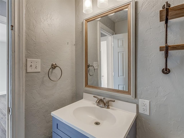 bathroom with a textured wall and vanity