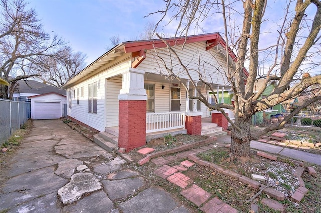 view of front of property featuring a garage, an outdoor structure, and covered porch