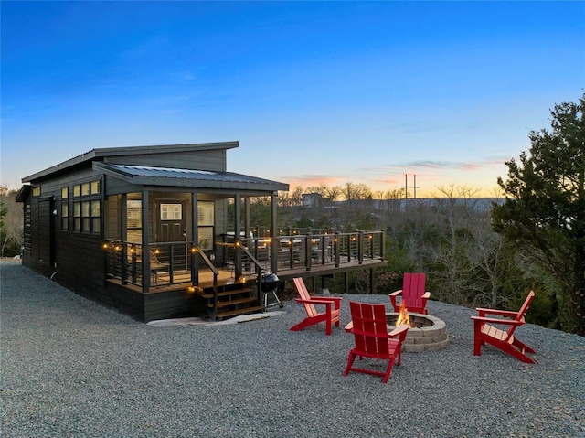 playground at dusk with a wooden deck and an outdoor fire pit