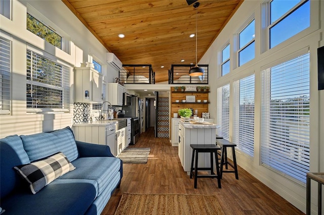 kitchen with white cabinetry, a kitchen island, a wall mounted AC, and wood ceiling