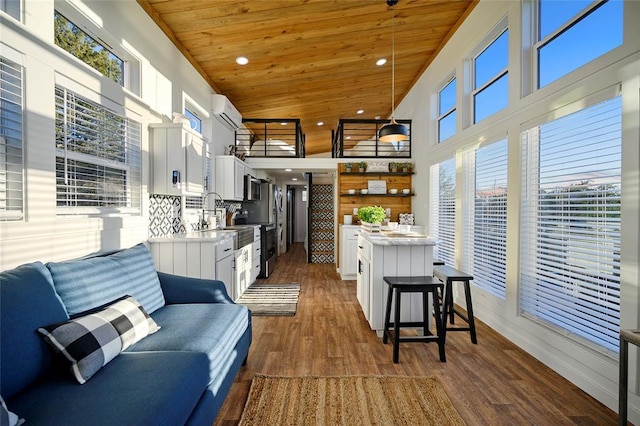 kitchen with a wall mounted air conditioner, white cabinets, wood ceiling, and decorative light fixtures