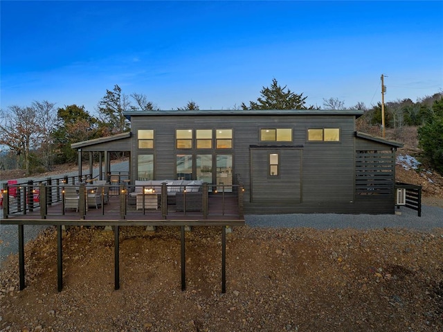 back of property featuring an outdoor hangout area and a deck