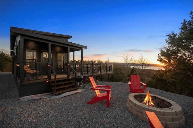 patio terrace at dusk with a wooden deck and a fire pit