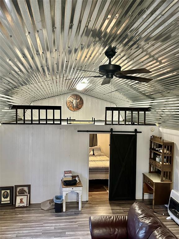 interior space with a barn door, hardwood / wood-style floors, and heating unit