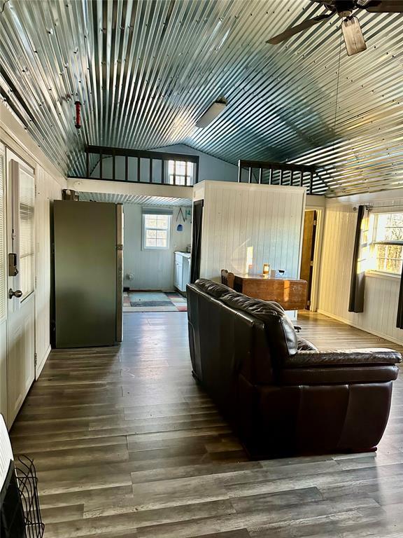 unfurnished living room featuring high vaulted ceiling, dark hardwood / wood-style floors, and ceiling fan