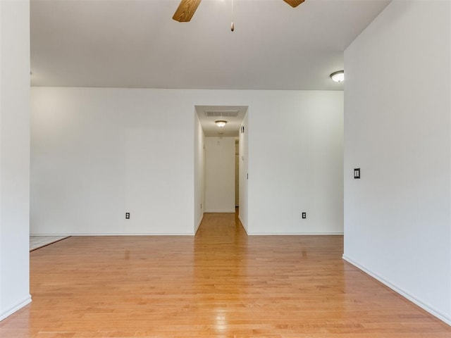 empty room with ceiling fan and light hardwood / wood-style flooring